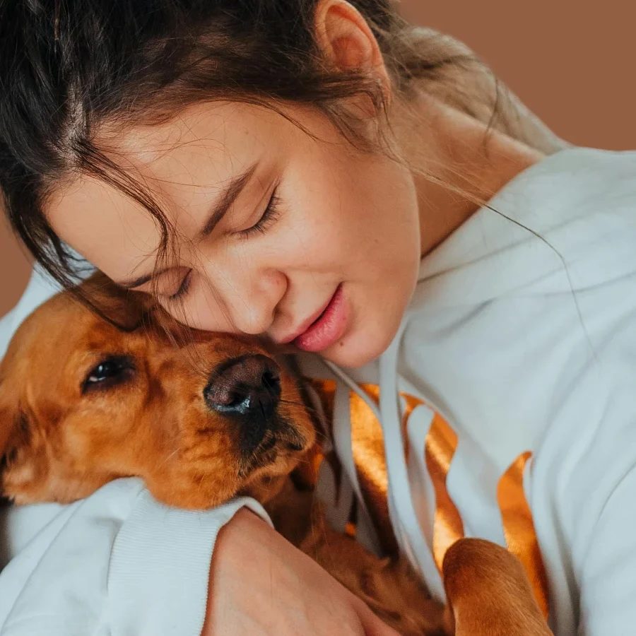 A young girl hugging and showering love on a happy dog.